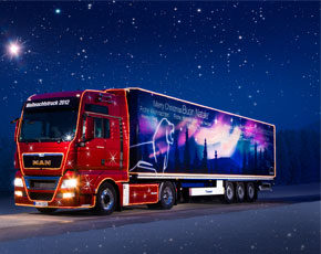 Man augura Buon Natale con il Christmas Truck